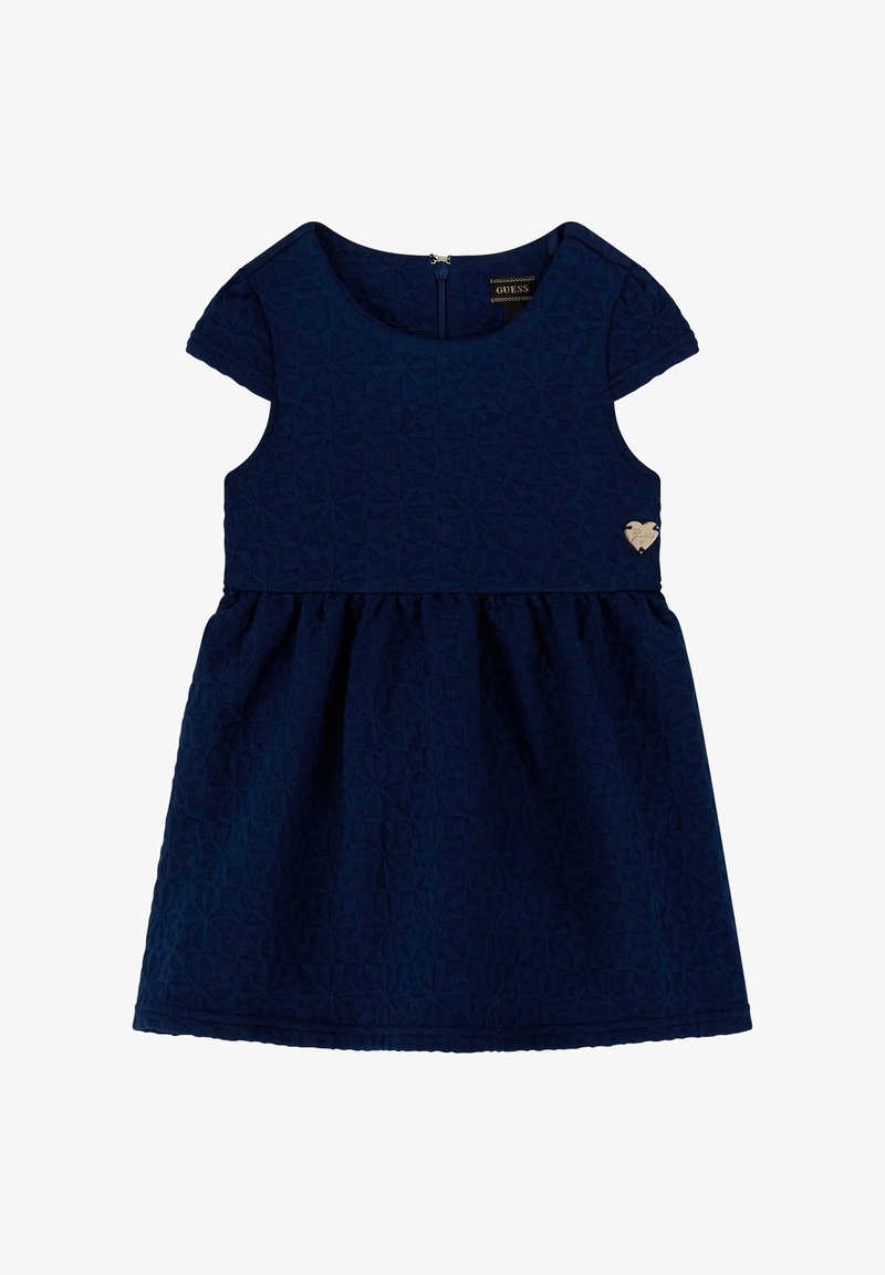 Tumši zilas krāsas kleita ar teksturētu ģeometrisku rakstu, īsām piedurknēm, apaļu apkakli un izplestu svārku; ar mazu sudraba sirds logotipu.