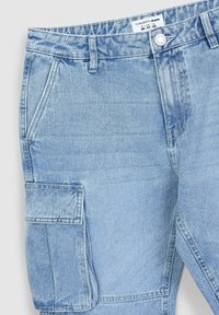 Pantaloni cargo in denim azzurro chiaro con tasca frontale e tasca cargo laterale. Presentano cuciture visibili e un sistema di chiusura con bottone metallico.