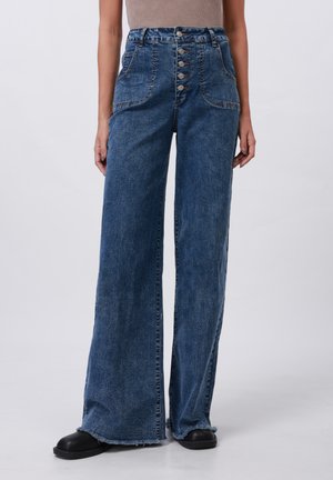 Pantalon en denim bleu à jambes larges avec une taille haute, doté d'une fermeture à cinq boutons, de poches latérales et d'un ourlet effiloché. Texture lisse et tissu résistant.
