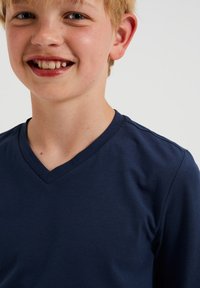 Sötétkék V-nyakú póló, puha pamut anyagból, rövid ujjakkal és sima textúrával, minta vagy díszítés nélkül.