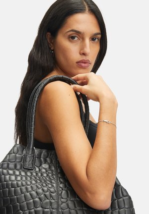 Schwarze Lederhandtasche mit einer strukturierten, krokodilgeprägten Optik. Verfügt über verlängerte Riemen und einen geräumigen Körper. Hintergrund ist rein weiß.