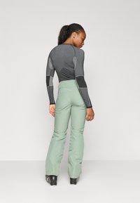 Grijze lange mouw basislaag top met textuuraccenten, gecombineerd met mintgroene high-waisted sneeuwbroeken, met een slim fit en flared benen.