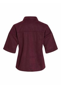 Bordas zamšādas krekls ar apkakli, īsām piedurknēm un brīvu piegriezumu. Gluda tekstūra ar vienkāršu dizainu un bez redzamas aparatūras.