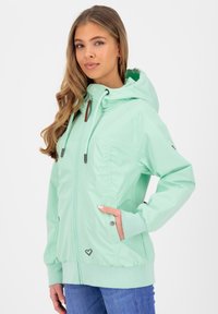 Mintgroene gewatteerde jas van lichtgewicht, soepel materiaal, voorzien van een rits aan de voorkant, elastische manchetten en twee zijzakken.