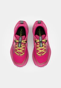 Zapatillas deportivas de color rosa brillante con parte superior de malla, cordones amarillos, detalles en negro y plata, y una suela texturizada. Presenta un logotipo en el costado.