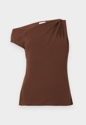 Smeđi top s jednim ramenom izrađen od mekog materijala. Ima drapirani detalj na ramenu i zakrivljenu donju ivicu.