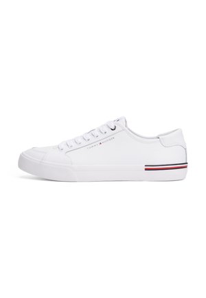 White low-top sneaker with white laces, subtle Tommy Hilfiger logo on the side, and red, white, and black stripe detail on the sole heel.