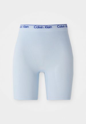 Lys blå boxer shorts med en marineblå "Calvin Klein" logo på livet, vist mot en hvit bakgrunn.