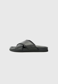 Svart sklidesandal med kryssede stropper, laget av glatt syntetisk materiale. Har en teksturert såle for godt grep. Enkel design, ingen dekorelementer.