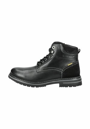 Botas de tobillo de cuero negro con una textura suave, costuras en gris que contrastan y una suela de goma con un diseño de tacos. Ojales de metal y un acento amarillo.