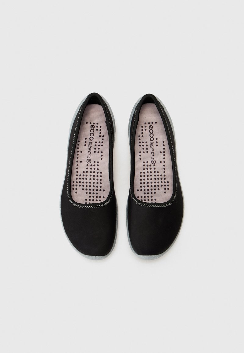 Czarne buty wsuwane z gładką górą z tkaniny, szaro-skalistej podeszwie i różowym wkładzie z kropkowymi wzorami wentylacyjnymi. Okrągły czubek.