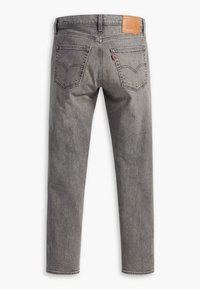 Gray denim jeans with a straight-leg cut, featuring two back pockets and a tan leather patch at the waist with embossed branding.