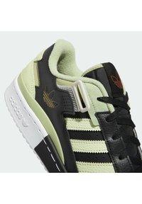 Svart och mintgrön sneaker med texturerat läder, tre svarta ränder och en vit sula. Utrustad med vadderad krage och framträdande logotypdetaljer.