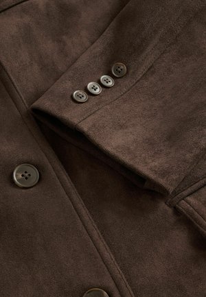 Bruine suedew jacket met een ingeknikte kraag, vijf knopen aan de voorkant en vier decoratieve knopen op de mouwen. Gladde textuur.