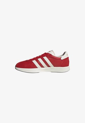 Roter Sneaker mit niedrigem Schaft, weißer Sohle, weißen Adidas-Drei-Streifen und weißem Fersenriegel, gezeigt in der rechten Seitenansicht.