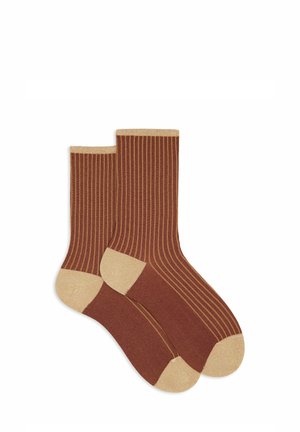 Braune, gerippte Socken mit beigen Akzenten am Bündchen und an der Spitze; aus weichem Stoff, mit vertikalen Streifen für Textur.