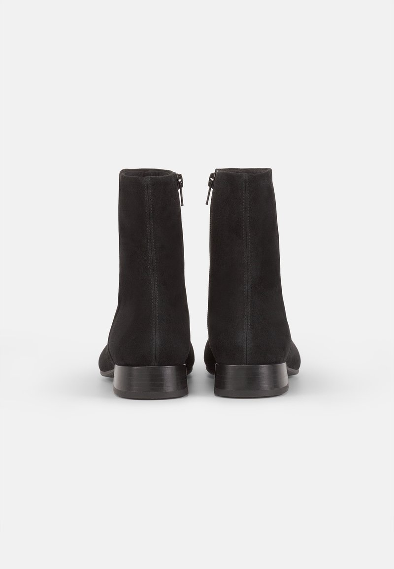 Schwarze Wildleder-Ankle-Boots mit einer glatten Textur, niedrigem Blockabsatz und seitlichen Reißverschlüssen für ein einfaches An- und Ausziehen.