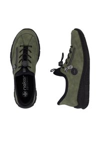 Scarpe in suede verde con punta rotonda, suola in gomma nera, cerniera decorativa e chiusura con lacci elastici. Presenta un logo sul lato.