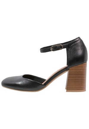 Zwarte leren pump met enkelbandje, een ronde neus en een gestructureerde houten blokhak. Heeft een minimalistisch ontwerp en een gladde afwerking.