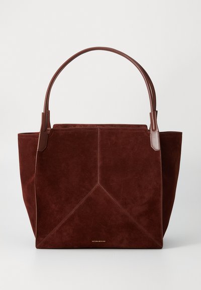 Burgundy velúr táska barna bőr fogantyúkkal, geometrikus varrási mintával és arany logóval az alján. Tágas és struktúrált forma.