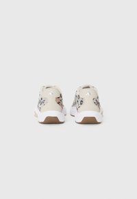 Baskets beige avec des accents léopard, semelles blanches et panneaux texturés. Présentent des lacets tressés et un logo de marque sur le talon.