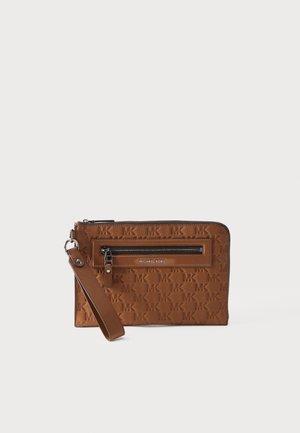 Brown Michael Kors wristlet clutch with embossed MK pattern, front zip pocket, and detachable strap on a white background.