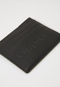 Porte-cartes en cuir noir avec le logo "VALENTINO" embossé, plusieurs emplacements pour cartes, texture lisse et couture contrastante le long des bords.