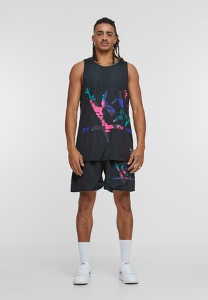 Svart mesh tank topp med flerfargede, abstrakte mønstre, kombinert med matchende svarte shorts med lignende design. Hvite sokker og joggesko.