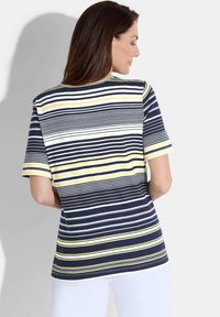 T-shirt rayé bleu marine et blanc avec des accents jaunes, à manches courtes, décolleté rond et coupe décontractée. Vue de dos, montrant les détails des épaules.