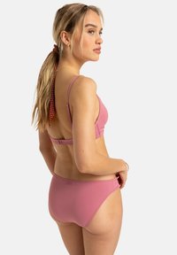 Rosa Badeanzug-Set mit einem einfachen BH und verstellbaren Trägern sowie einem passenden Bikini-Höschen, glatte Textur und minimalistisches Design.