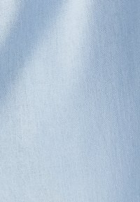 Svetlo modra tkanina z gladko in enakomerno teksturo. Material se zdi lahek in mehko padajoč, brez izrazitih vzorcev ali poudarkov.