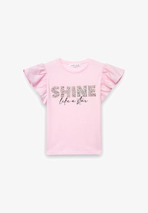 Różowy bawełniany t-shirt z krótkimi, falbaniastymi rękawami. Na przodzie znajduje się błyszczący napis „SHINE” oraz czarny kursywny napis „like a star” poniżej. Gładka faktura.