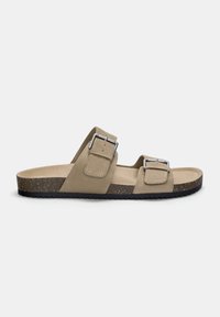 Tvåremmad sandal i beige mocka med silverspännen, korkfotbädd och svart gummisula, med en platt design och minimalistisk stil.