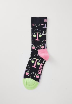 Black socks with pink and green justice scale patterns. Features a colorful toe, heel, and the word "HAPPY" in pink. Made of soft material.