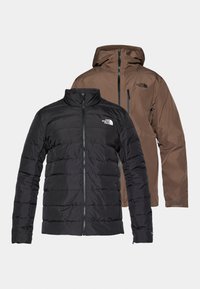 Puffer jacket in black with horizontal quilting and stand-up collar, layered under a brown, water-resistant hooded jacket with zip closure.