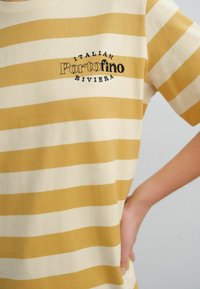Gestreept T-shirt in gele en crèmekleurige katoen met korte mouwen, met geborduurde tekst "Italian Portofino Riviera" op de voorkant.