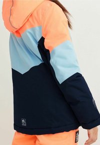 Color-blocked winter jacket featuring a coral hood, light blue upper, and navy lower sections. Made from synthetic material with a soft texture.