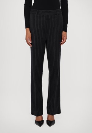 Zwarte gestreepte pantalons in een op maat gemaakte stijl, met een rechte pijp en een gladde stoffen textuur, gecombineerd met puntige zwarte schoenen.