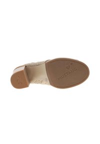 Chaussure à talons beige avec un dessus à motifs, dotée d'un talon épais et d'une semelle en caoutchouc texturée. Logo visible sur la semelle.