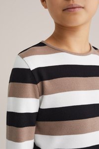 Svītrains džemperis ar horizontālām svītrām melnā, baltā un brūnu toņu krāsās. Redzam ribotu tekstūru un apaļu kakla izgriezumu.