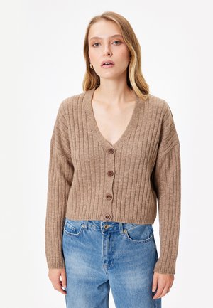 Brauner gerippter Cardigan mit einem tiefen V-Ausschnitt, Frontknöpfen und langen Ärmeln. Getragen mit hellblauen, hoch taillierten Jeans. Glatte Textur.