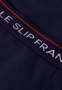 Marine slip met een zachte, gladde textuur en een contrasterende tailleband met "LE SLIP FRANCAIS" in het wit en oranje gedrukt.