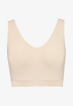 Soutien-gorge de sport beige clair avec un large décolleté en V, design sanscoutures, texture lisse et couleur unie partout. Offre un soutien moyen.