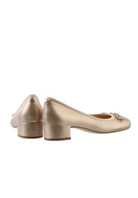 Gold ballet flats with a rounded toe, small block heel, and decorative bow detail on the front. Smooth metallic finish and elastic edges.