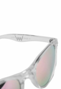 Průhledné sluneční brýle s iridescentními čočkami, s elegantním, úhlovým designem a transparentním rámem s jemným brandingem na straně.
