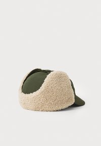Grønn caps med beige faux shearling øreklapper. Har buet visir og knappedetalj på toppen. Myk tekstur med kontrastmaterialer.