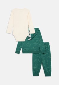 Conjunto de sudadera y pantalones de chándal con estampado de dinosaurios verdes y un body de manga larga en crema. Material de algodón suave con puños acanalados.