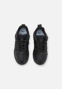 Svarta sneakers med en slät läderovandel, texturerade designdetaljer, snörning och logotypaccenter på tungan och innersulan.