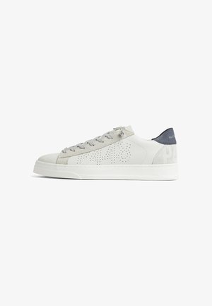 Zapatilla blanca de piel tipo low-top con detalles en ante gris, diseño lateral perforado, cordones grises y lengüeta trasera de color gris oscuro.