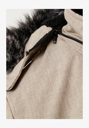 Gai beidge zīmodu jaka ar strukturētu audumu, kurai ir mākslīgā kažokāda apkakle tumši pelēkā krāsā un melni rāvējslēdzēja akcenti.